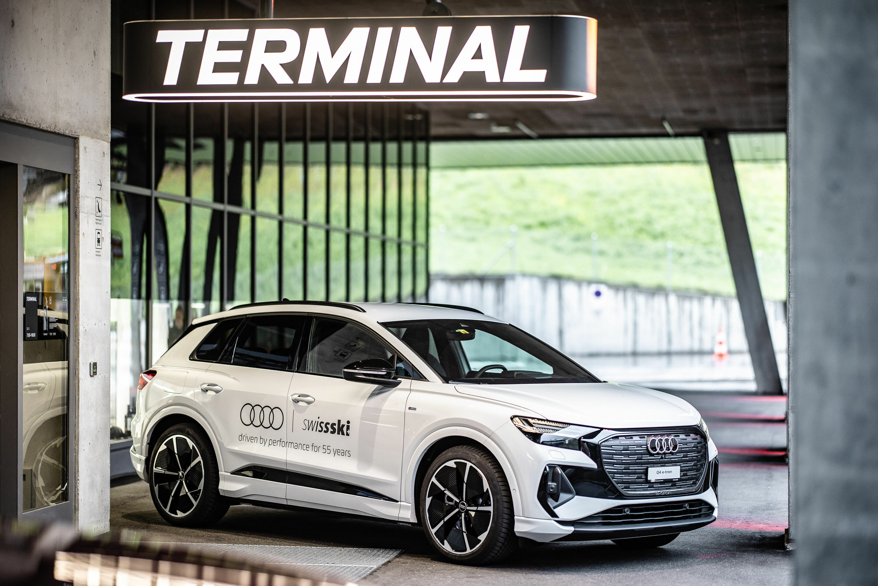 55 years AMAG / Audi x Swiss Ski - The Audi Q4 e-tron in glacier white in front of the Eiger-Express terminal in Grindelwald, Switzerland.