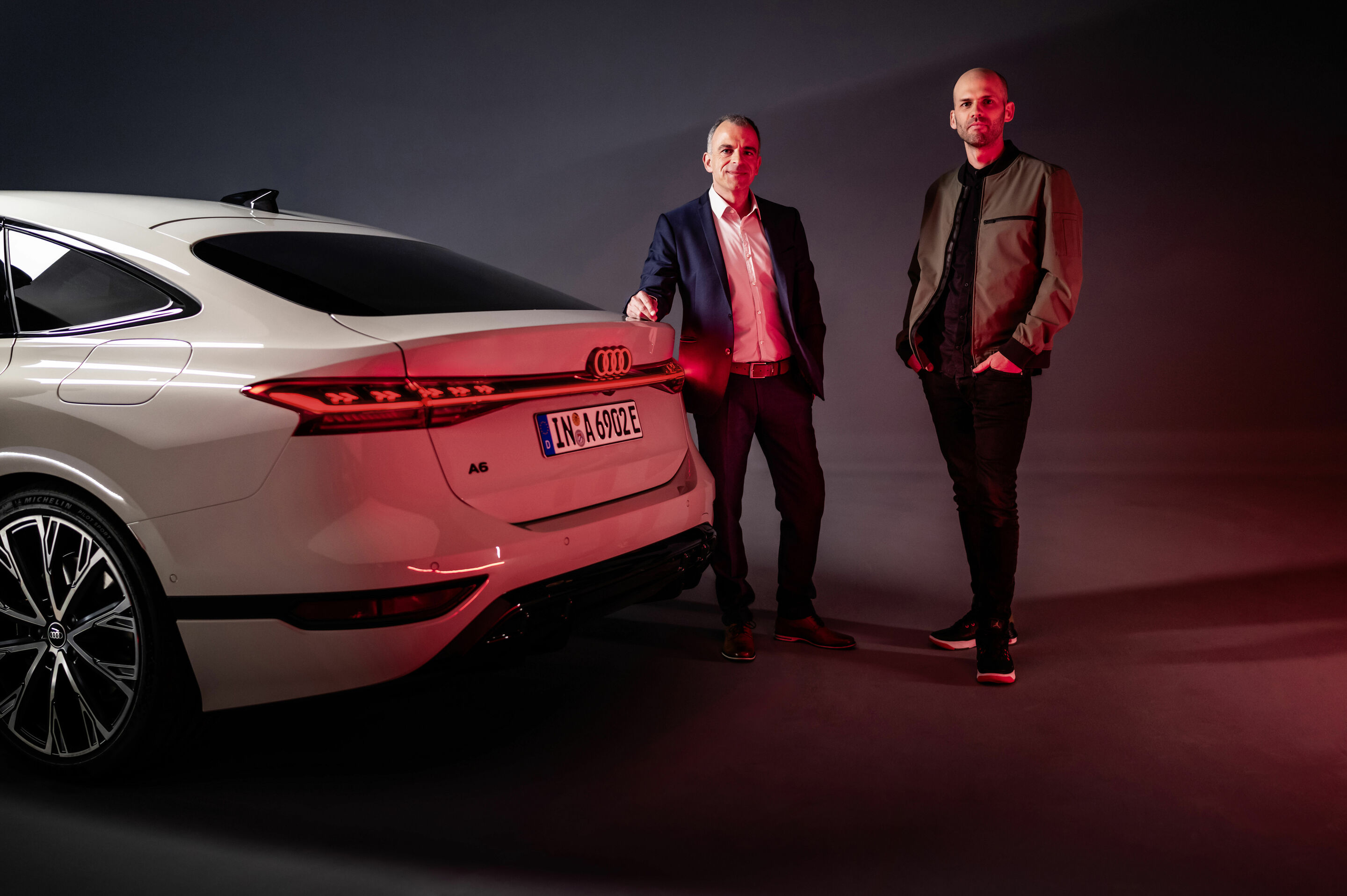 Illuminating insights! - Stefan Staudacher (left), head of rear lighting development, and lighting designer Christoph Häußinger (right) stand together at the back of the new Audi A6 Sportback e-tron.